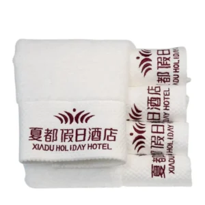 folded white bath towels with custom embroidered hotel logo
