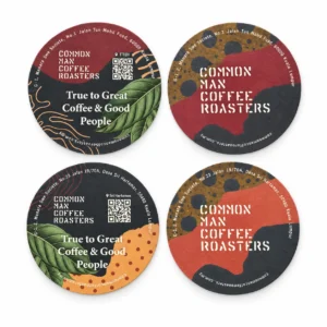 Custom printed round cardboard coasters in full colour with Common Man Coffee Roasters logo and QR code